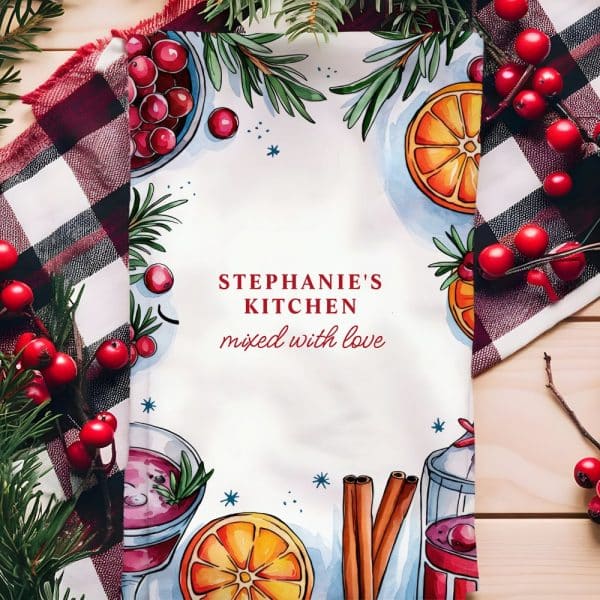 A Kitchen Tea Towel Featuring Watercolor Illustrations Of Cranberries, Oranges, Cinnamon Sticks, And Warm Drinks, With The Text Stephanie'S Kitchen, Mixed With Love.