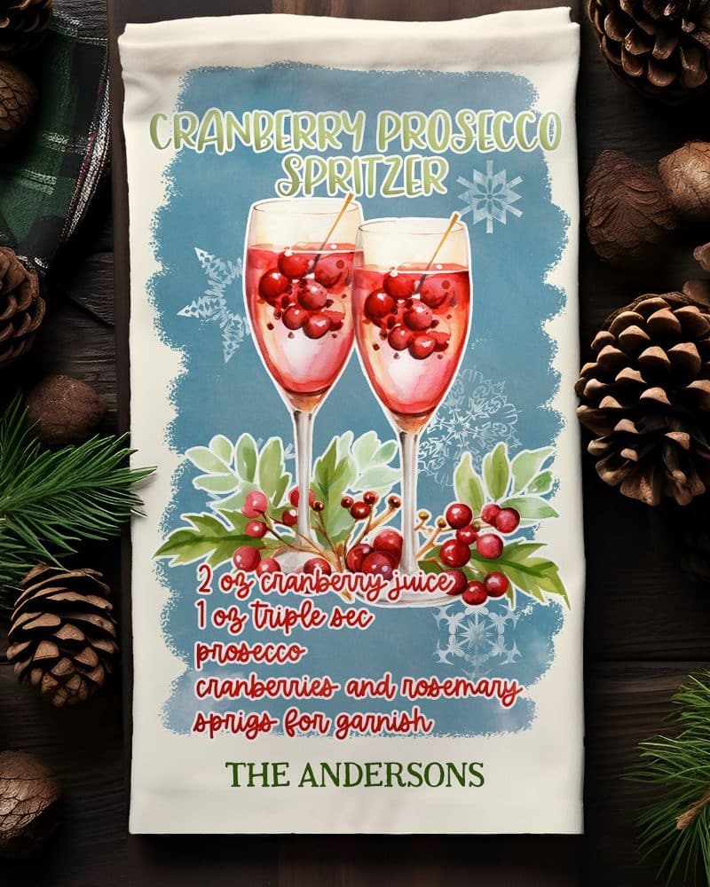 Personalized kitchen towel featuring a watercolor illustration of two glasses of cranberry prosecco spritzer, with recipe and name.