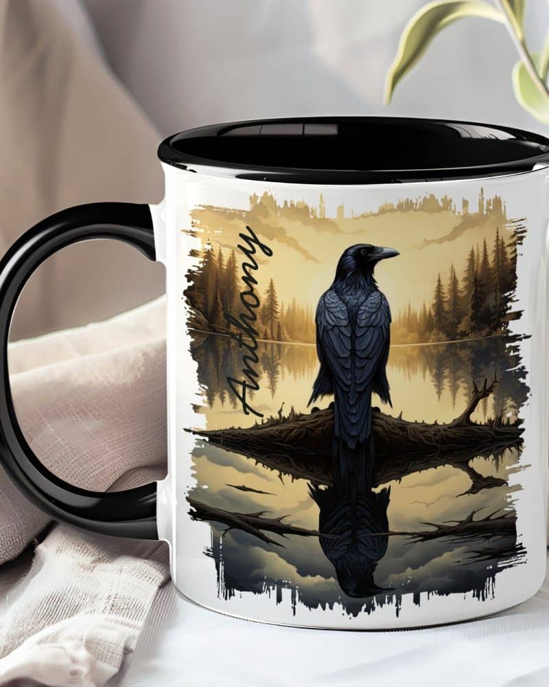 Black mug with a black handle, featuring a raven perched on a branch over water at sunset, personalized with the name Anthony.