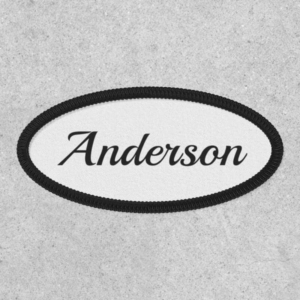 Oval White Name Tag With Black Border And The Name Anderson In A Cursive Font.