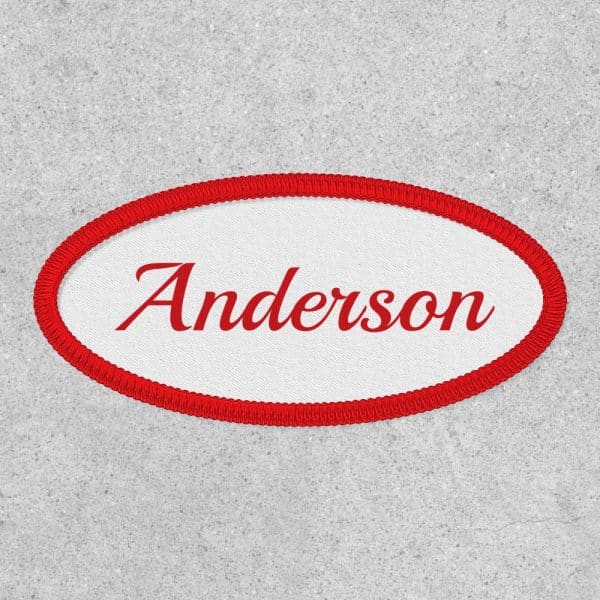 Oval Red-Bordered Name Tag With The Name Anderson In Red Script.