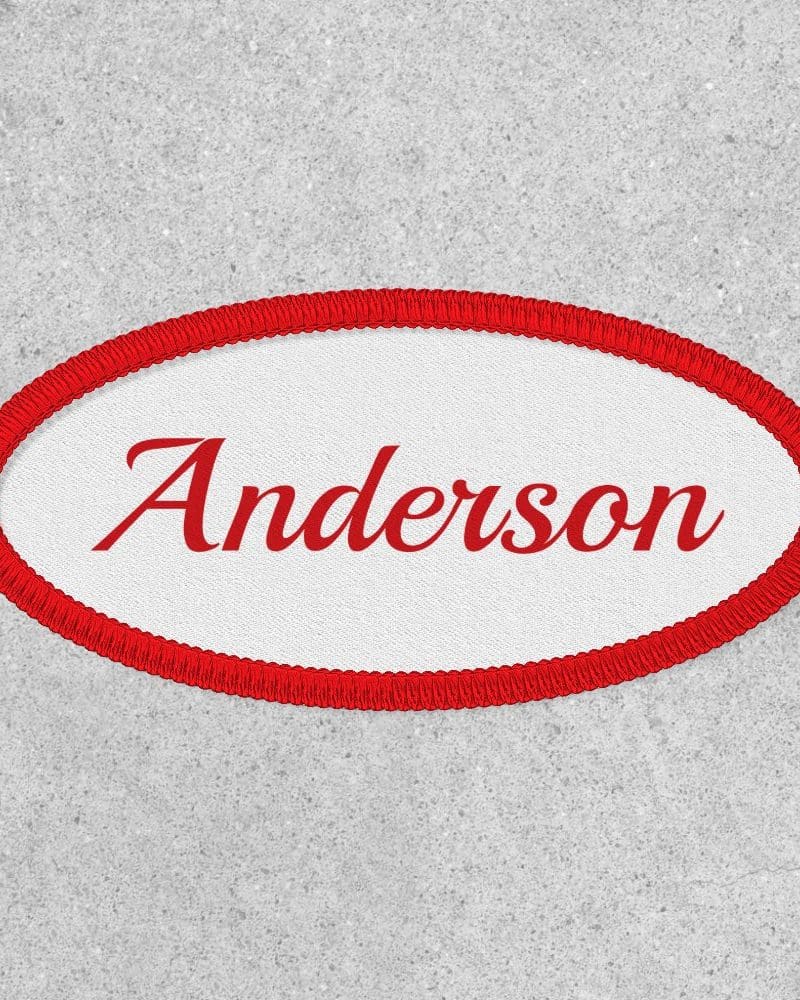 Oval red-bordered name tag with the name Anderson in red script.