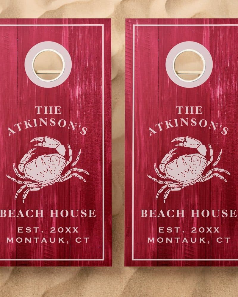 Pair of red wooden cornhole boards, each featuring a crab illustration and "The Atkinsons' Beach House, Montauk, CT" text.