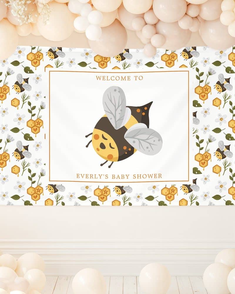 Baby shower banner featuring a large cartoon bee and text that reads Welcome to Everly's Baby Shower. The banner has a repeating pattern of smaller bees and honeycombs.