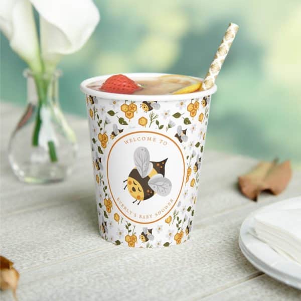 A Paper Cup With A Bee-Themed Design For A Baby Shower, Featuring A Cartoon Bee And The Words &Quot;Welcome To Everly'S Baby Shower&Quot;.
