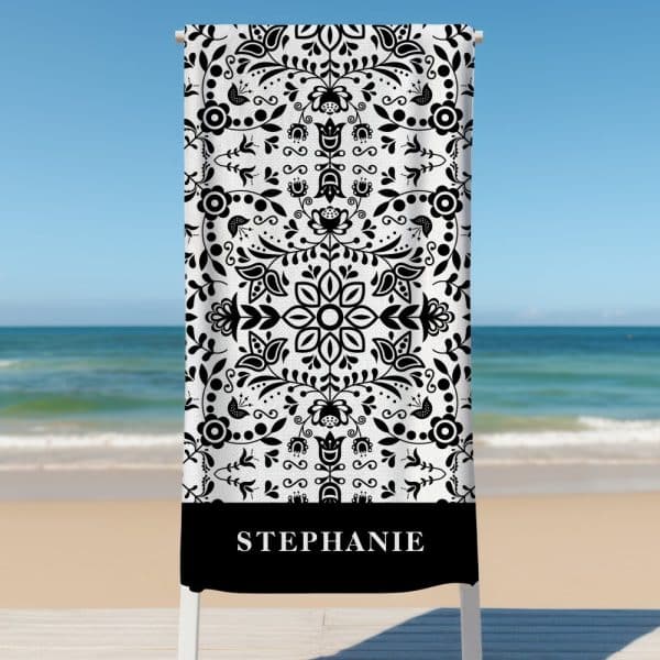 A Black And White Beach Towel With A Floral Pattern And The Name Stephanie At The Bottom.