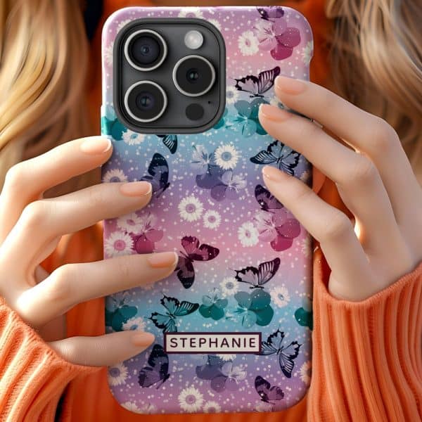 A Person Holds Up A Pastel Phone Case Featuring A Pattern Of Butterflies And Flowers. The Name Stephanie Is Visible On The Case.