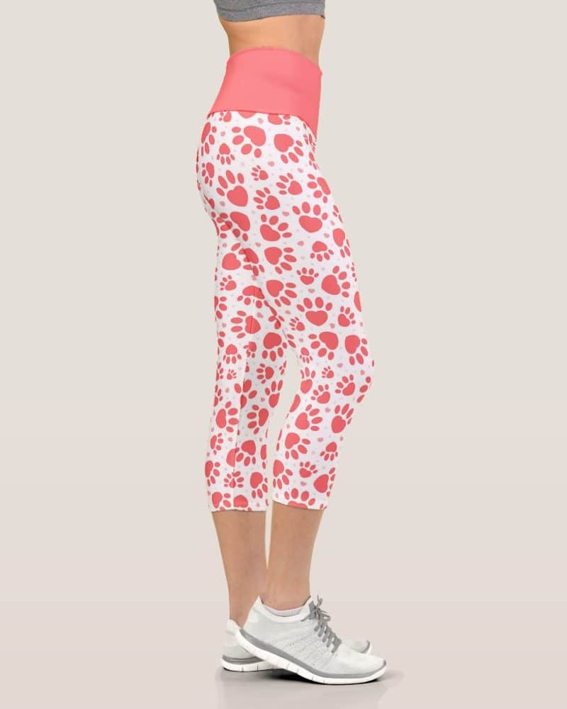 Coral paw print cropped leggings on a woman.
