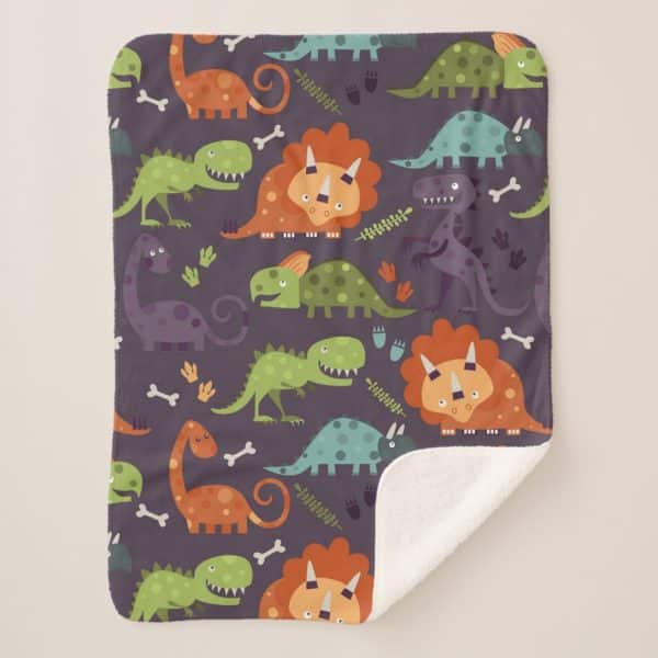A Fleece Blanket With A Repeating Pattern Of Colorful Cartoon Dinosaurs On A Purple Background.