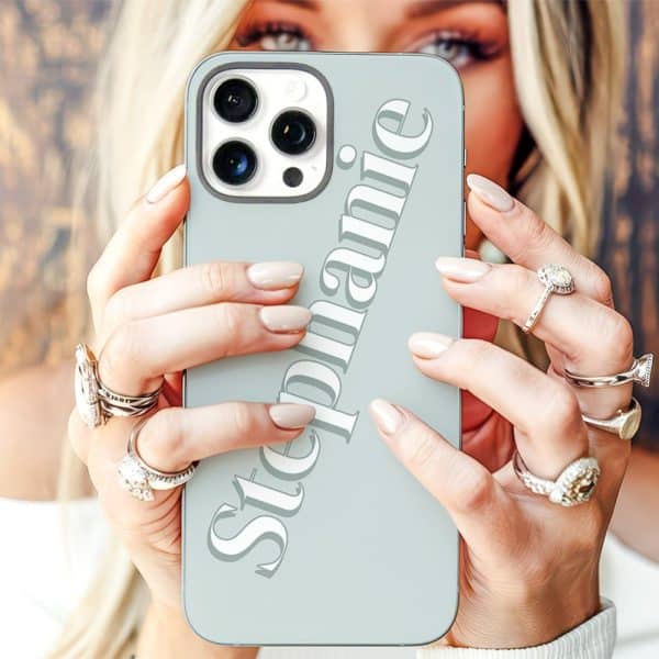 A Woman'S Hands Holding A Light Blue Iphone Case With The Name Stephanie Printed On It.