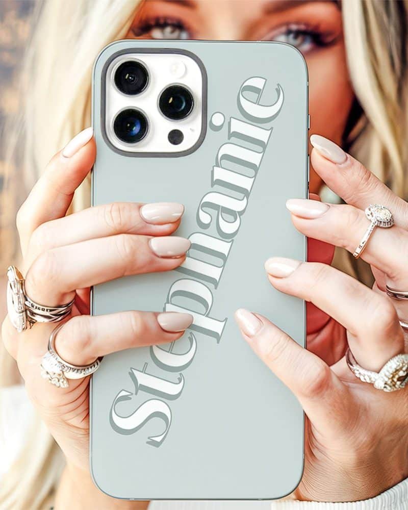 A woman's hands holding a light blue iPhone case with the name Stephanie printed on it.