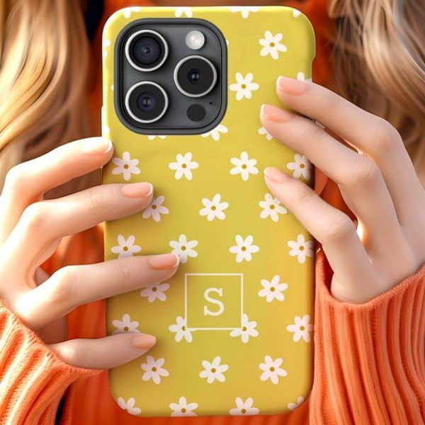 Hands Holding A Yellow Iphone Case With A White Daisy Pattern And The Letter S In A White Square.