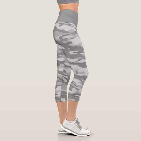 Side View Of A Woman'S Legs Wearing Gray Camouflage Cropped Leggings And White Athletic Shoes.