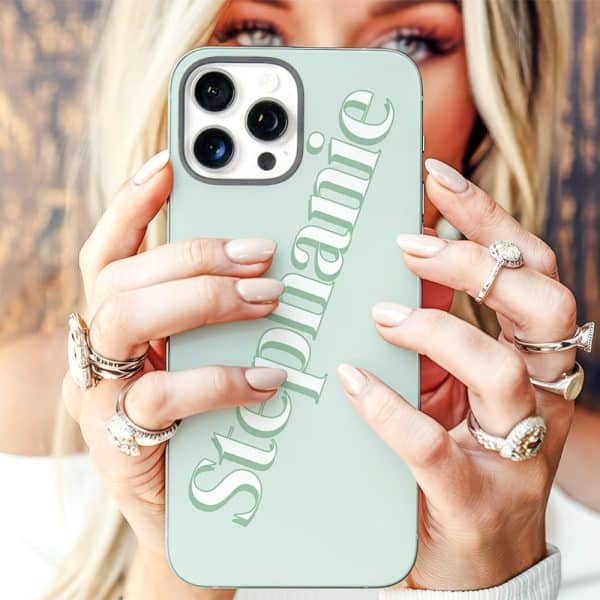 Close-Up Of A Woman'S Hands Holding A Light Green Iphone Case With The Name Stephanie Printed On It.