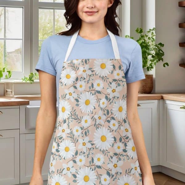 A Woman Wearing A Peach-Colored Apron Adorned With A Daisy Floral Pattern.