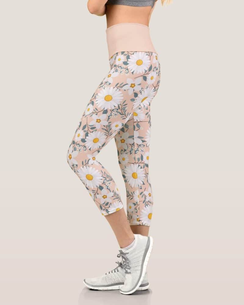 Woman wearing peach-colored cropped leggings with a white daisy print.