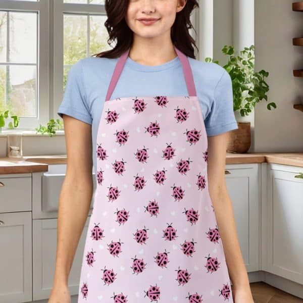 Woman Wearing A Pink Apron With A Ladybug Pattern.
