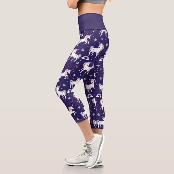 Purple Capri Leggings With A Repeating Pattern Of White Unicorns, Rainbows, And Stars.