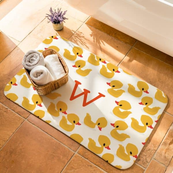 Bath Mat With Yellow Rubber Duckies And The Letter W.