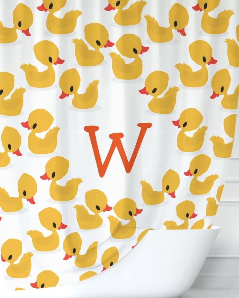 Shower curtain with yellow rubber duckies and a large orange W.