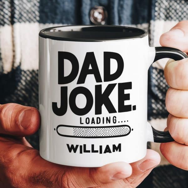 A Hand Holds A White Coffee Mug With Black Text That Reads Dad Joke. A Progress Bar Below Says Loading, And The Name William Is At The Bottom.