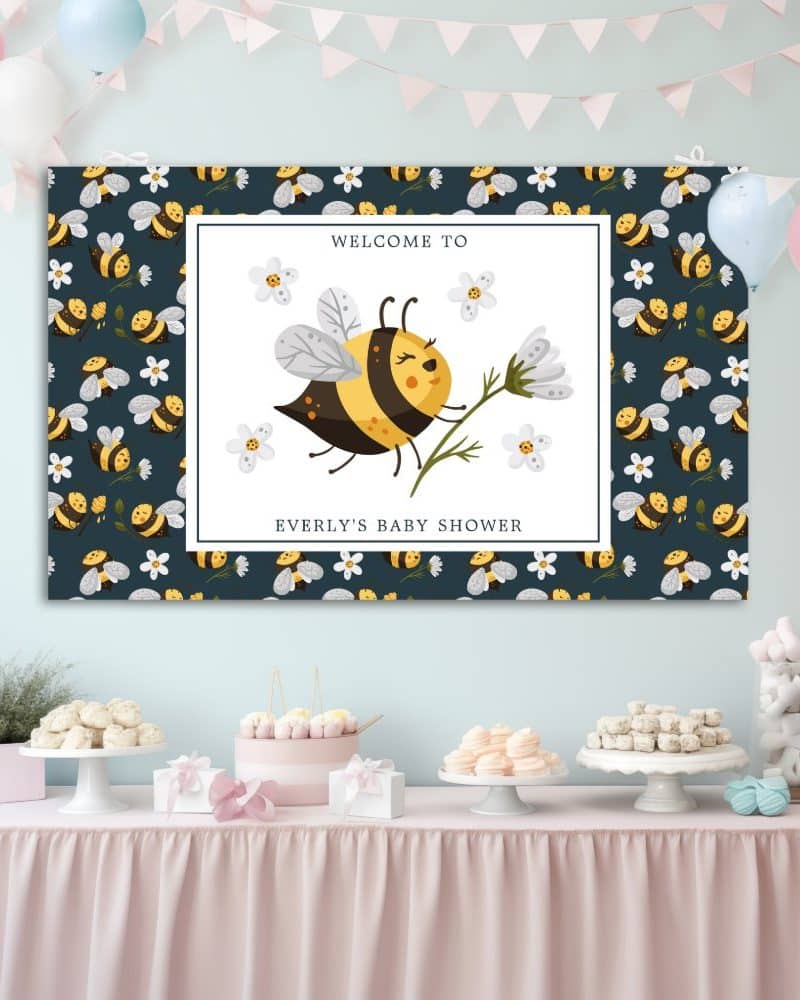 Baby shower banner featuring a cute cartoon bee holding a flower. The banner has a dark background with a repeating bee pattern.