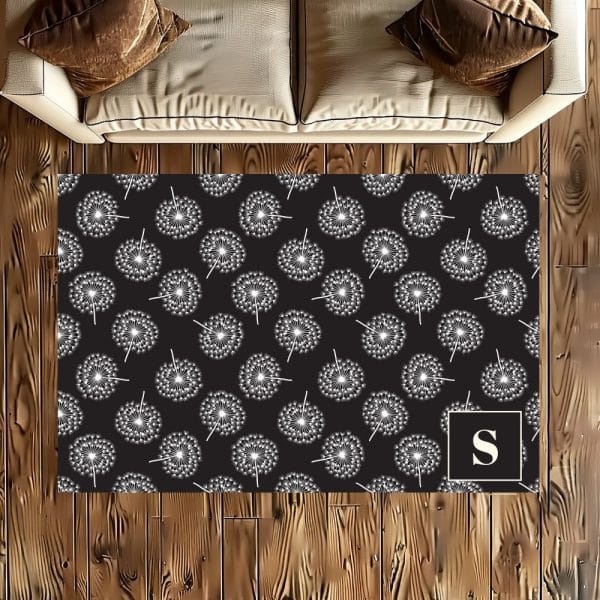 Black Rug With A White Dandelion Pattern And A White Letter S In The Corner.
