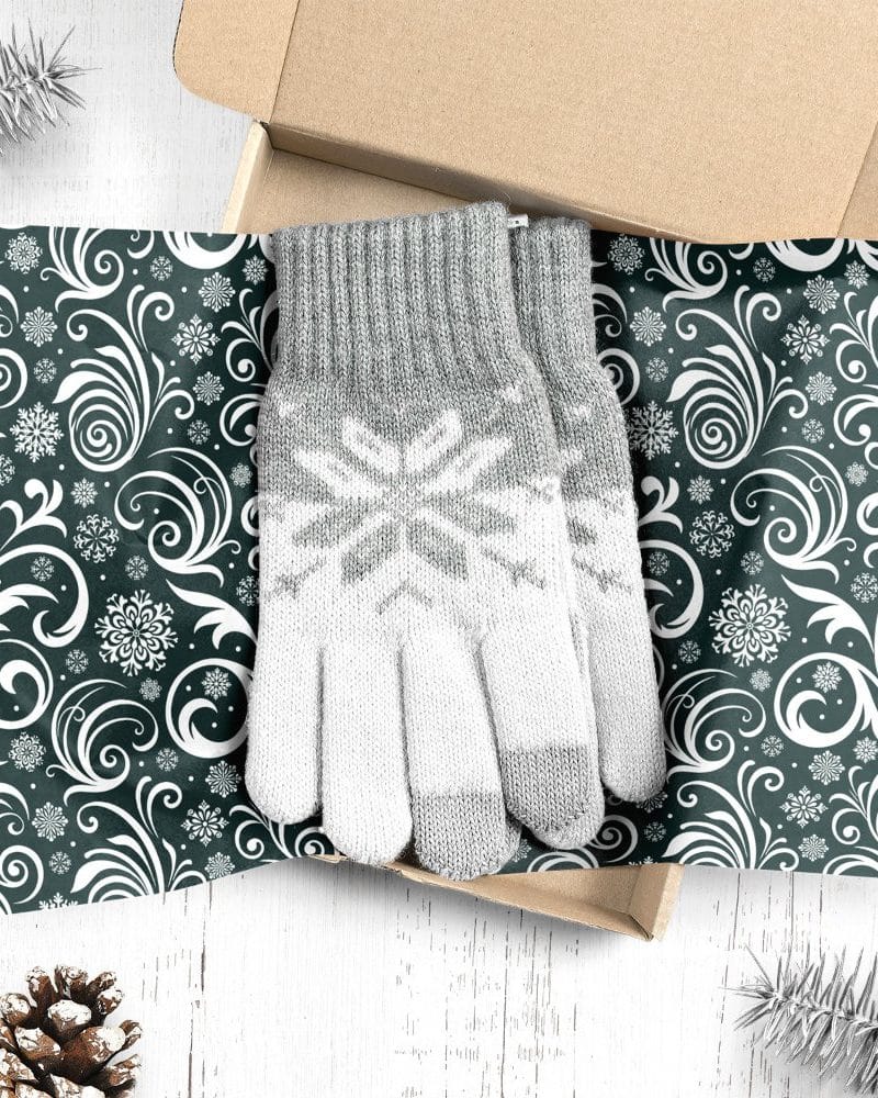 Pair of grey and white knit gloves with snowflake pattern in a gift box.