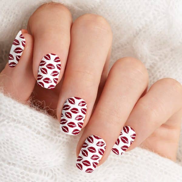 Close-Up Of A Hand With Nails Adorned With A Red Lips Print Design.