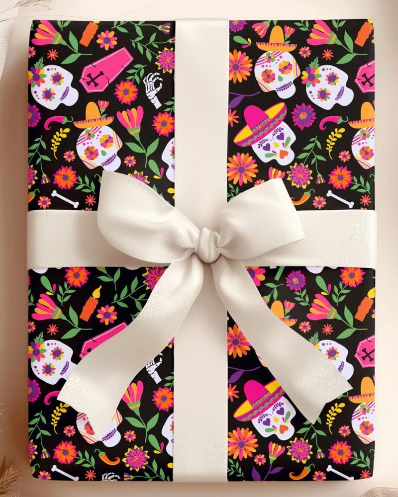 Gift wrapped in Day of the Dead themed paper featuring sugar skulls and flowers.