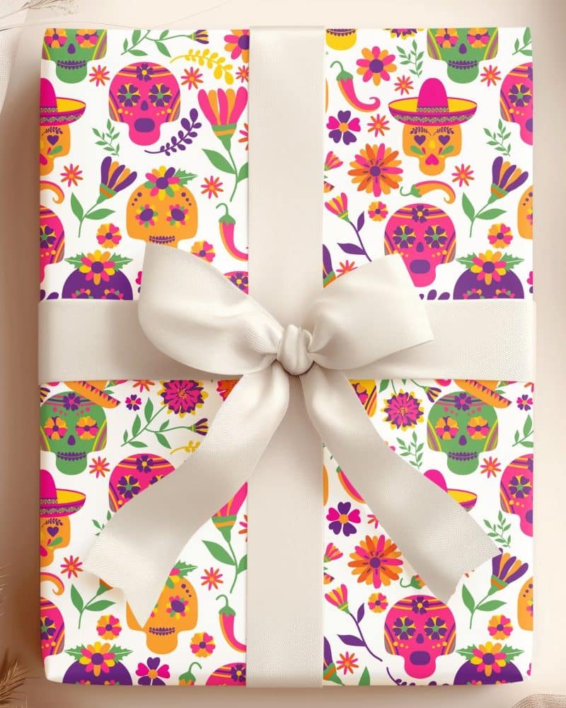 A gift wrapped in colorful Day of the Dead patterned paper, tied with a cream-colored ribbon.