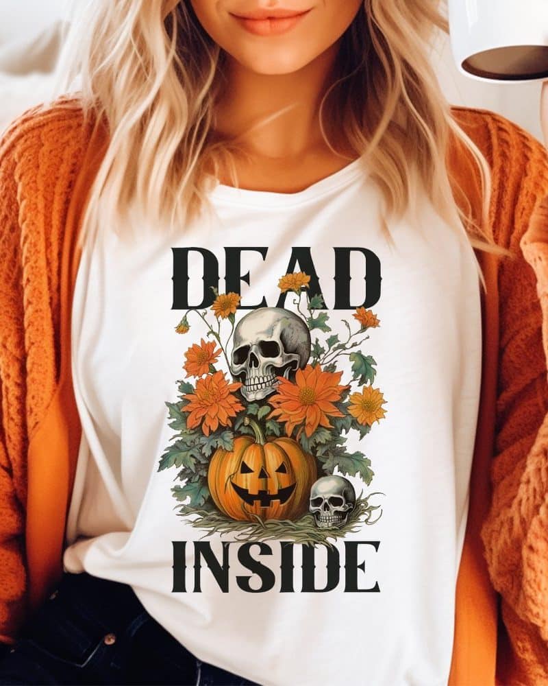 White shirt with a Halloween design: a skull nestled in orange flowers atop a jack-o'-lantern, with the words Dead Inside above and below.