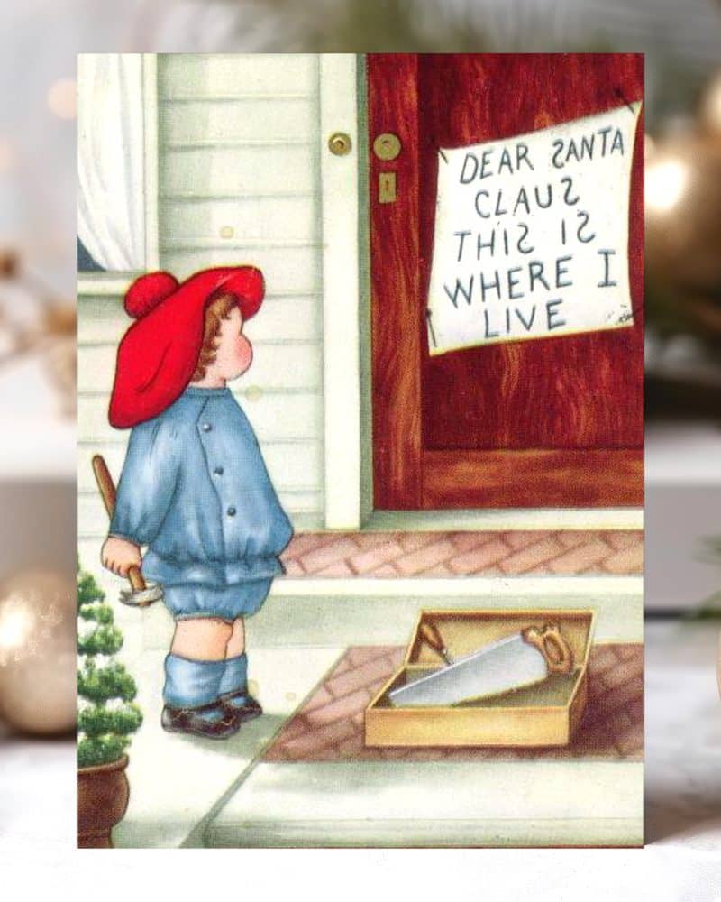 A young child in a red hat and blue overalls stands on a porch, holding a hammer near a box of tools and a sign that reads "Dear Santa Claus This is where I live".