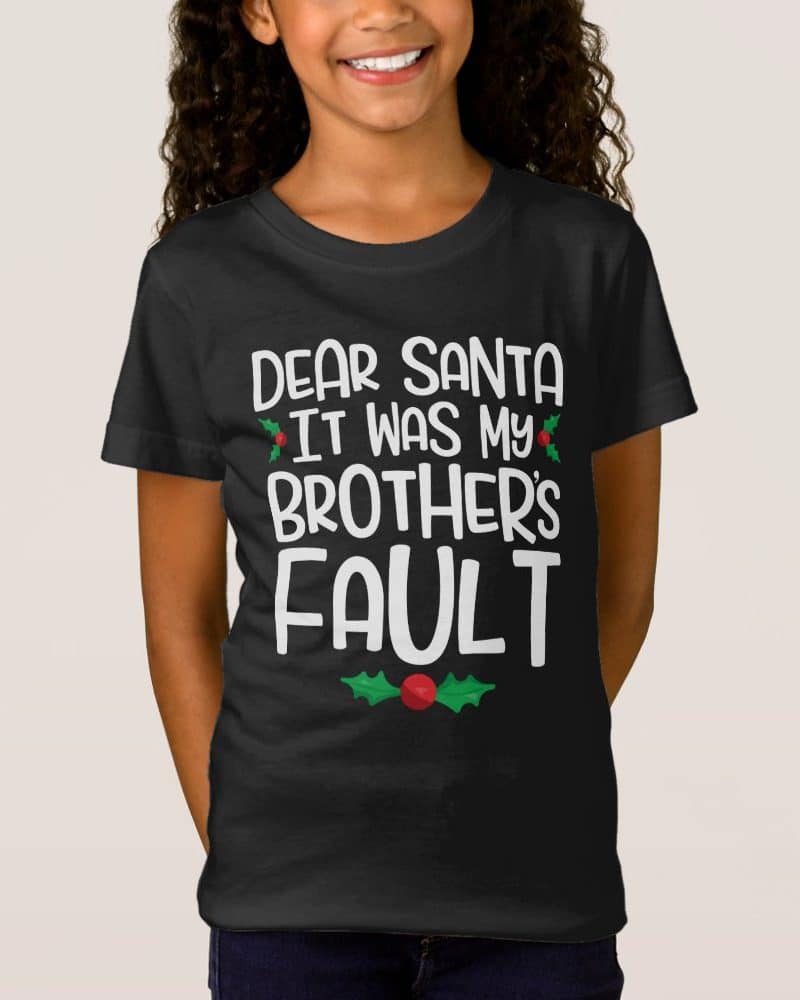 Girl wearing a black t-shirt that says Dear Santa It Was My Brother's Fault.
