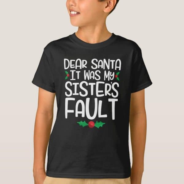 A Child Wearing A Black T-Shirt That Says Dear Santa It Was My Sister'S Fault.