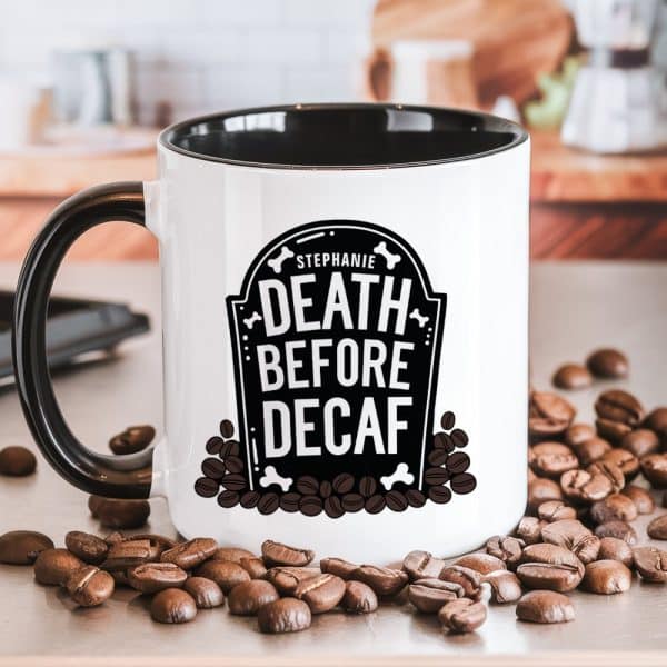 A White Coffee Mug With A Black Interior And Handle, Displaying The Personalized Text Stephanie, Death Before Decaf, Within A Tombstone Graphic Surrounded By Coffee Beans.