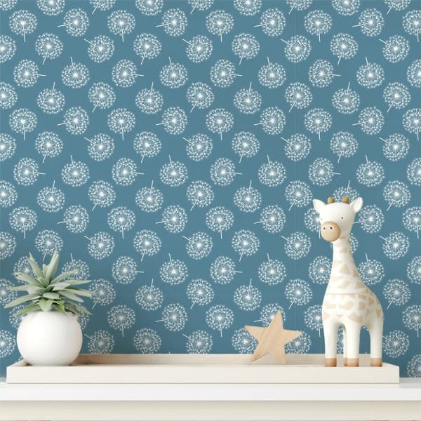 A Teal Wall With A Repeating Pattern Of White Dandelions, Featuring A Small Wooden Giraffe And Plant On A Shelf In Front.