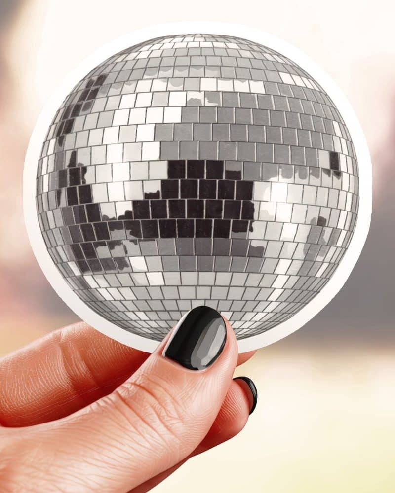 Hand holding a sticker of a disco ball.