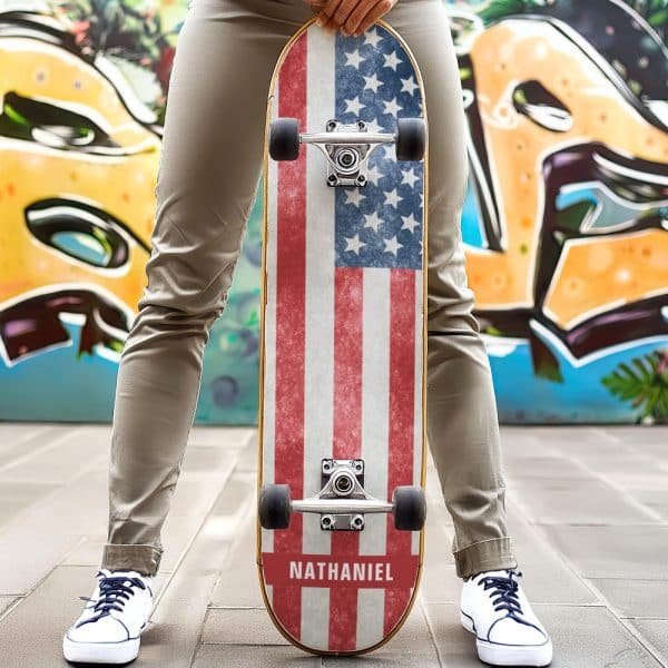 Person Holding A Skateboard With A Distressed American Flag Design And The Name Nathaniel At The Bottom.