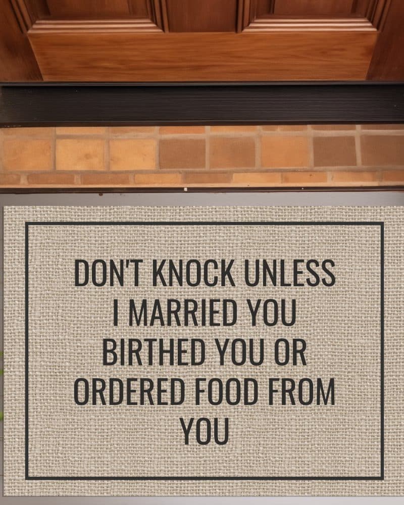 A tan doormat with black text that reads Dont knock unless I married you birthed you or ordered food from you.