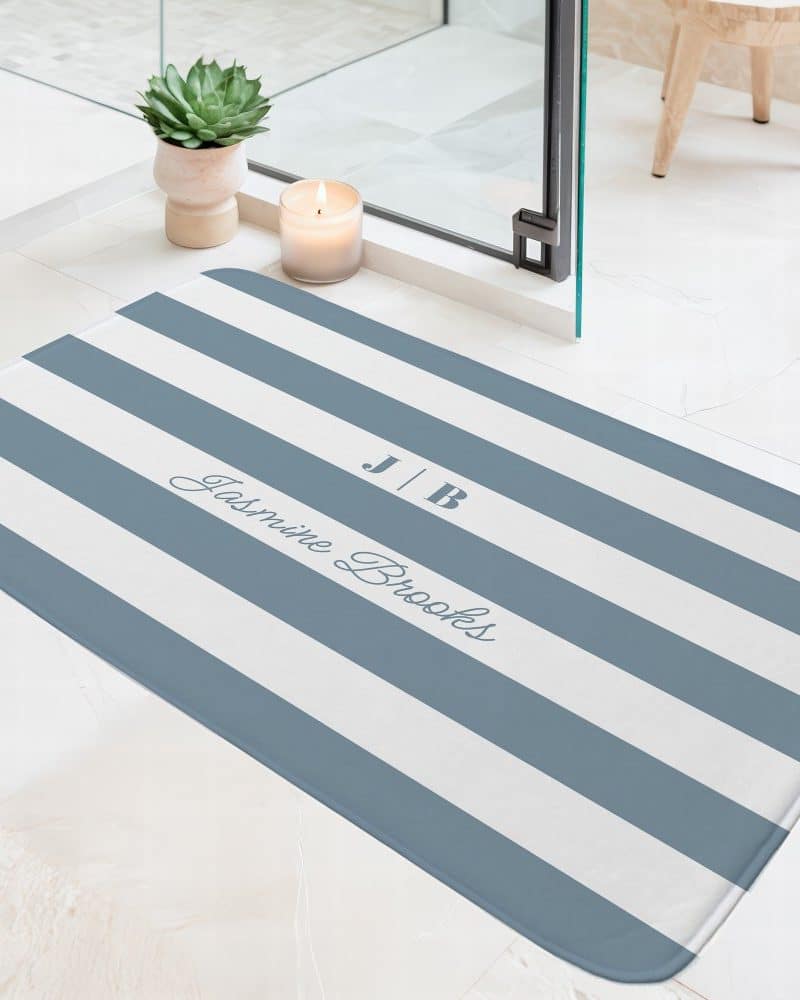 A blue and white striped bath mat with the initials JB and the name Jasmine Brooks.