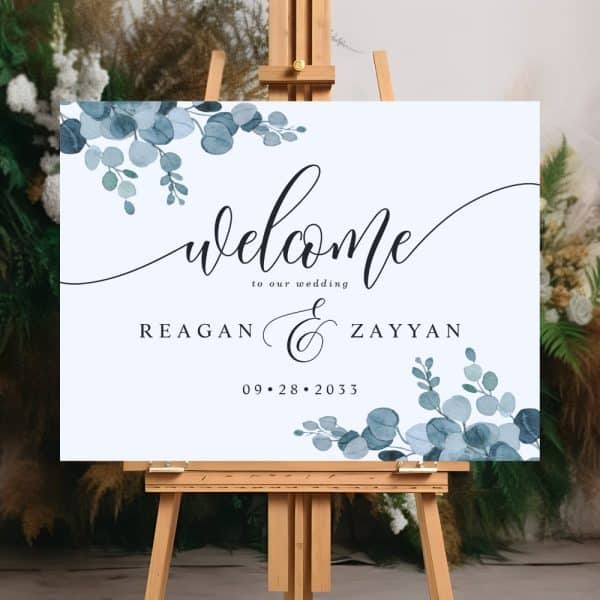 Wedding Welcome Sign With Blue Eucalyptus Leaves, Announcing Reagan And Zayyan'S Wedding On September 28, 2033.
