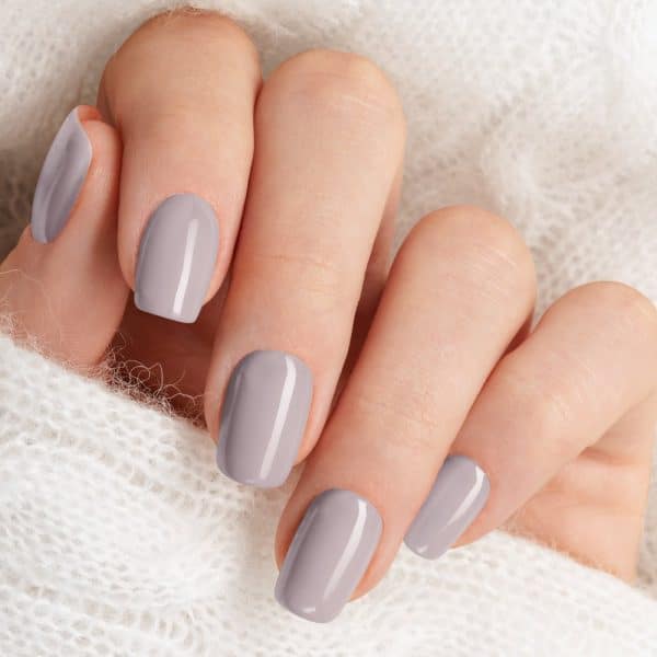 Close-Up Of A Hand With Light Gray Nails.