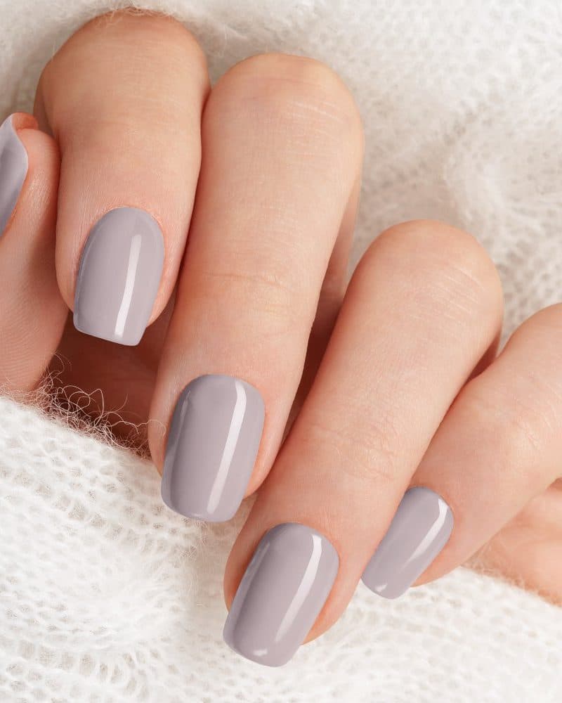 Close-up of a hand with light gray nails.