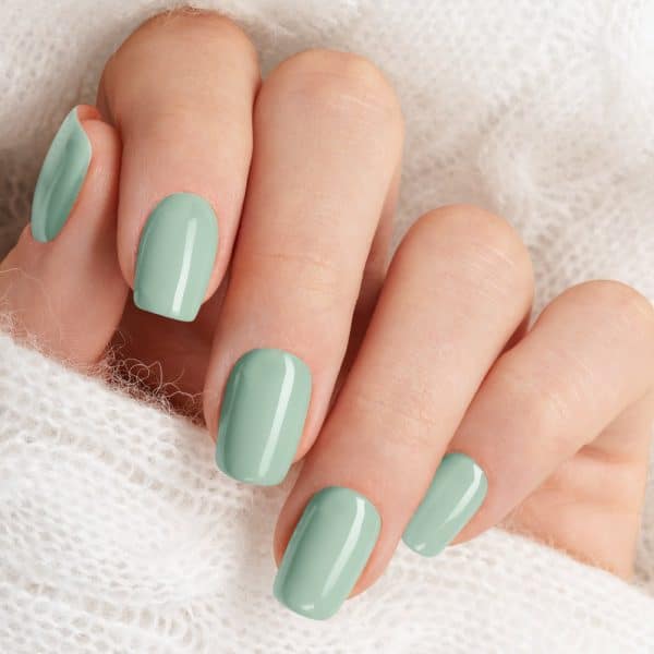 Close-Up Of A Hand With Pale Green Nail Polish.