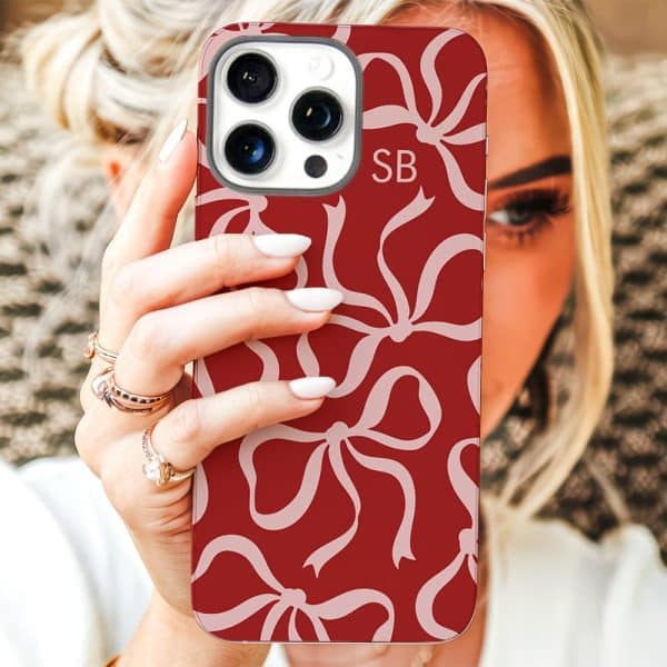 Woman Holding A Red Phone Case With A Pink Bow Pattern.