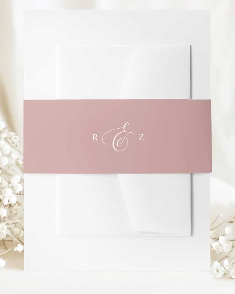 Wedding invitation with a blush pink band and white lettering showing the initials R and Z.