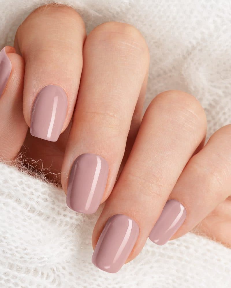 Close-up of a hand with light pink nails.