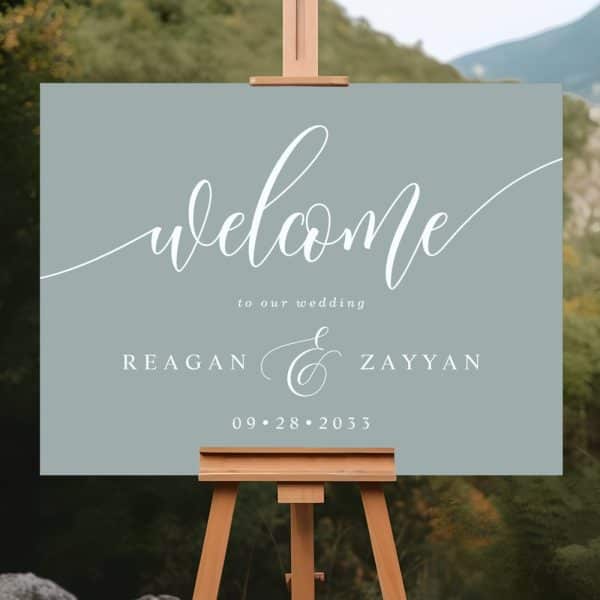Sage Green Wedding Welcome Sign With Calligraphy Lettering. It Displays The Names Reagan &Amp; Zayyan And The Date September 28, 2033.