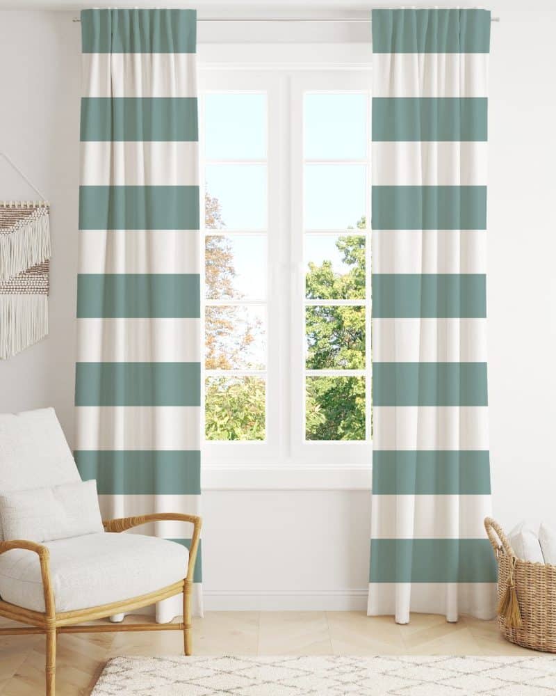 A pair of teal and white striped curtains hang in front of a window.